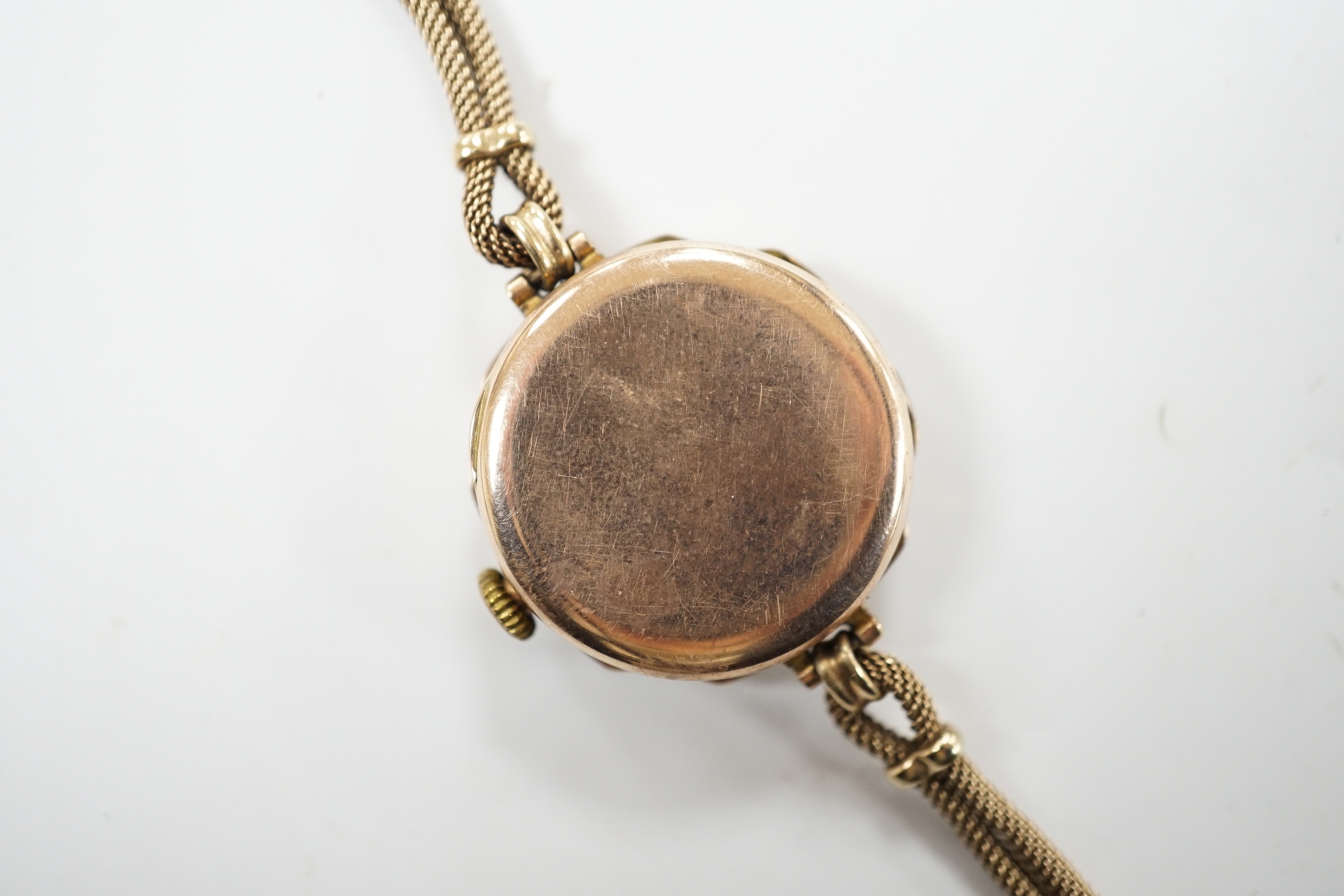 A lady's 1920's 9ct gold Rolex manual wind wrist watch, with sunburst Arabic dial, on a 9ct twin strand Vertex bracelet, gross weight 18.8 grams.